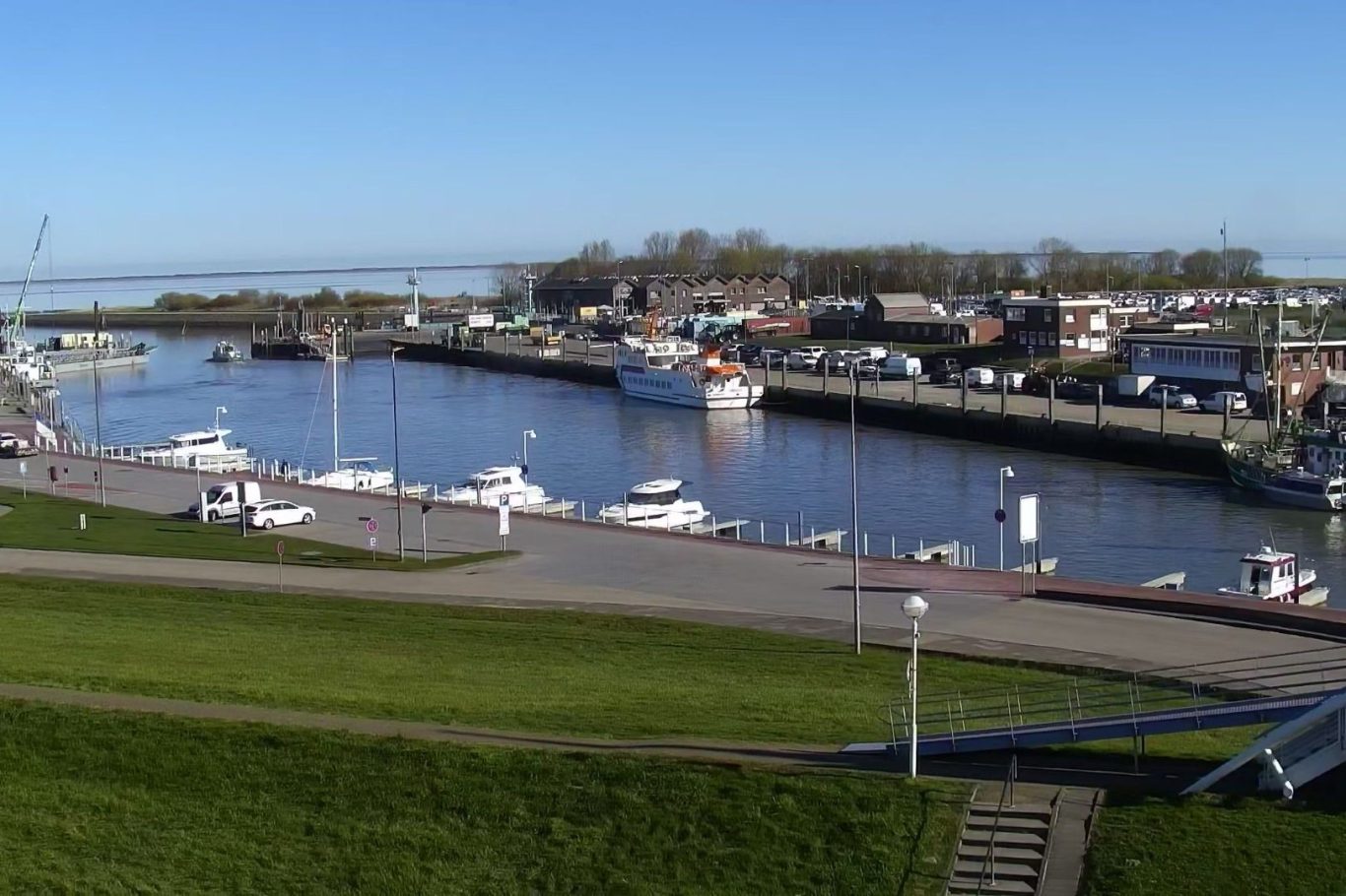 Hafenansicht mit Booten, klarer Himmel und ruhigem Wasser in Bensersiel